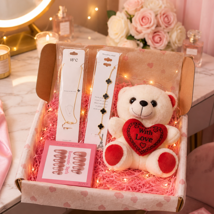 Romantic gift box featuring a plush teddy bear holding a heart, gold-toned jewelry, and press-on nails.
